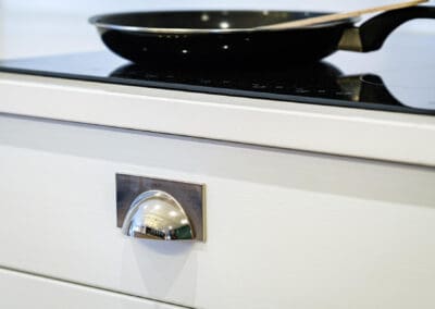 Clasic white drawer under electric hob with chrome handles