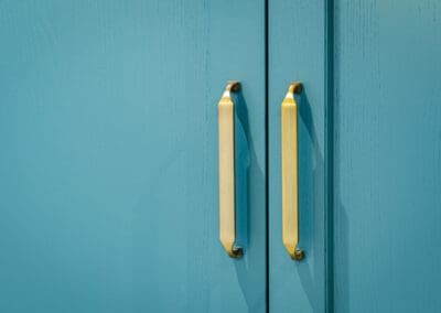 Mangan Woodcraft modern teal kitchen cabinet doors with brass handles