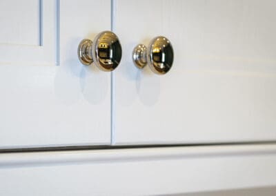 Metal knobs on white kitchen design